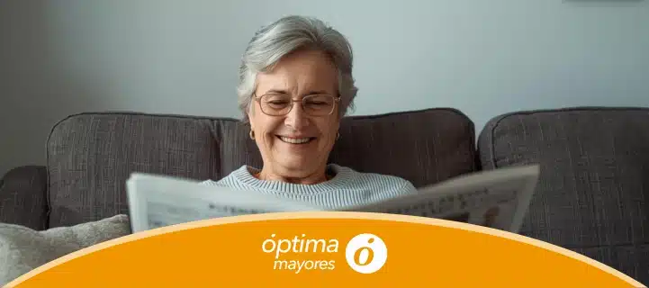 Señora de unos 60 años, aparentemente contenta leyendo un artículo